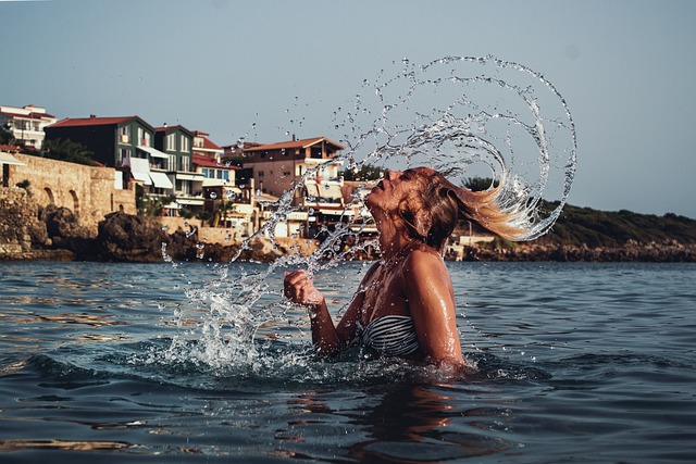 mulher loira na agua balaçando o cabelo