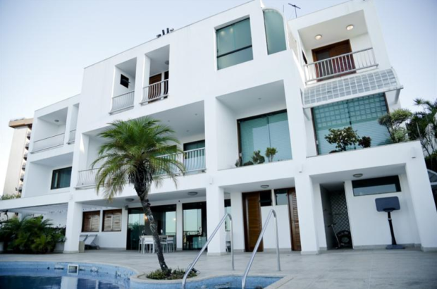 Lei da Atração: Sinta e Atraia o Que Você Quer Uma casa de 3 andares branca com piscina