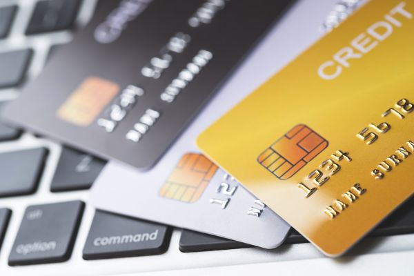 Surpreenda da Mastercard. Tutorial Completo Aqui cartão de credito preto, amarelo e cinza em cima de um teclado de computador