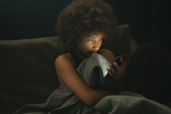 o que é solidão uma garota sentada olhando o celular