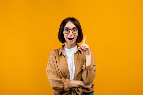 dicas para saúde mental fundo cor de abóbora com mulher apontando dedo pra cima, sorrindo e com olhos arregalados
