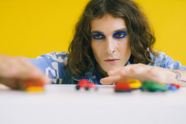 síndrome de peter pan homem com olhos pintados brincando com carrinhos
