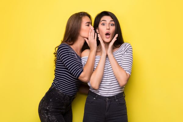 fofoca duas garotas fofocando com fundo amarelo