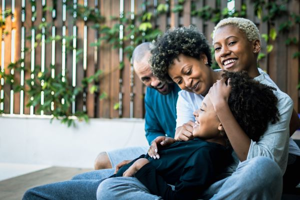 responsabilidade afetiva homem, duas mulheres e uma criança sentados sorrindo