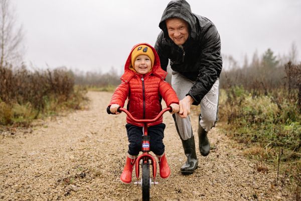 responsabilidade afetiva pai empurrando uma criança de bicicleta