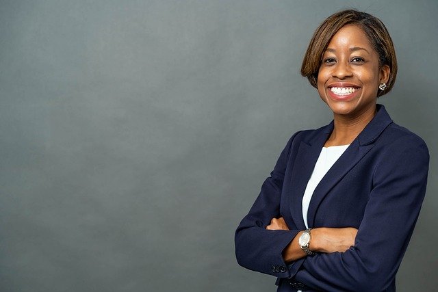 mulher negra sorrindo com roupa de empresária