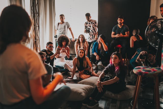 uma mulher dando palestra para vários jovens