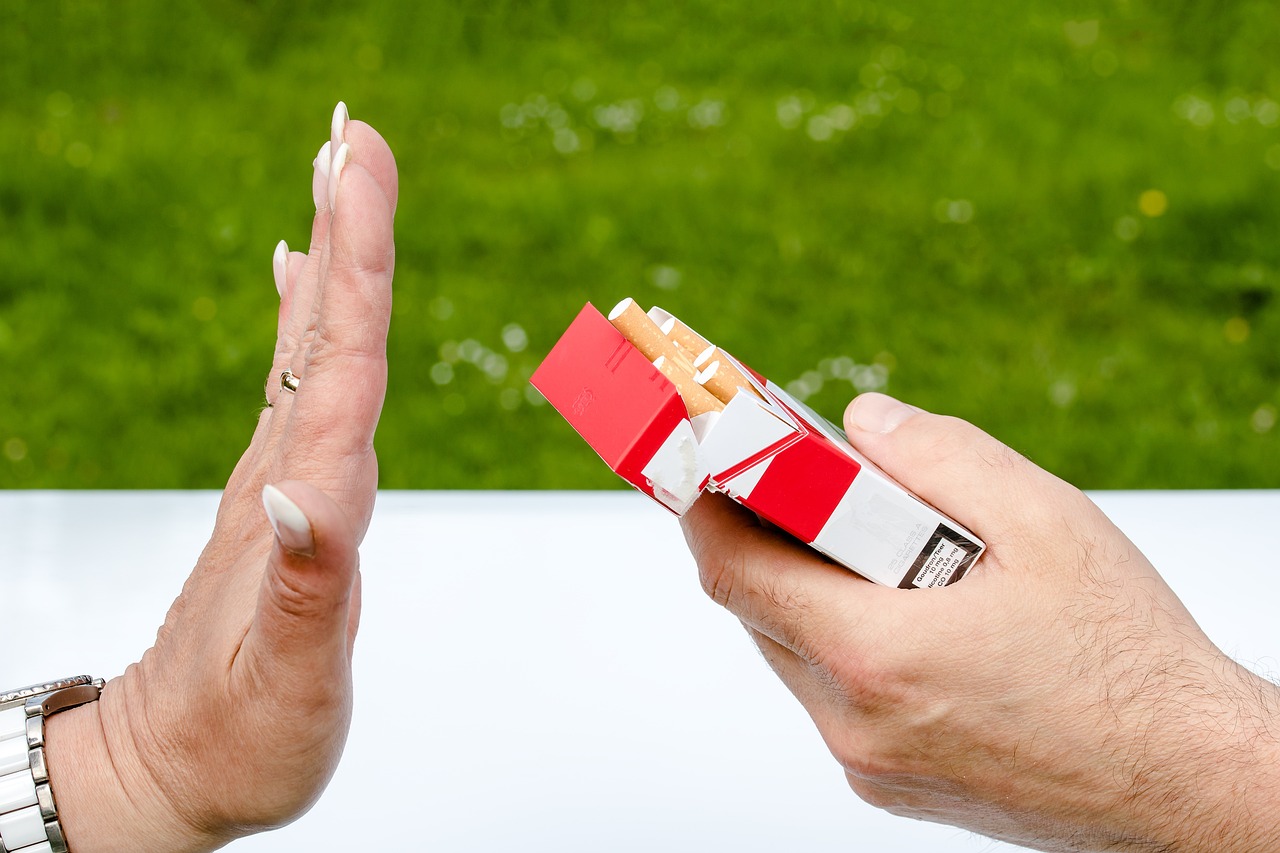 uma mão recusando a aceitar de outra mão um cigarro