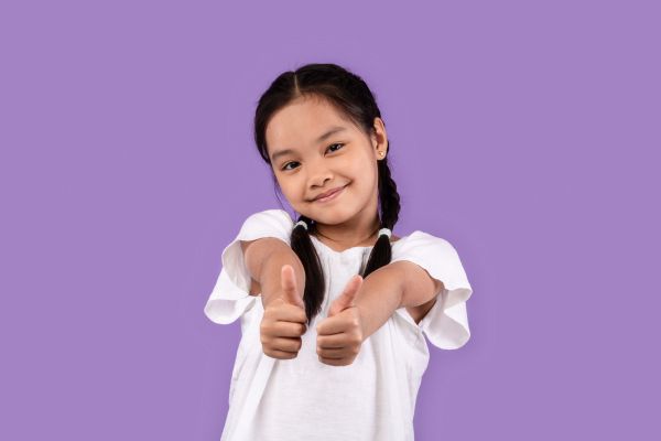 uma menina criança fazendo okei com dedos da mão