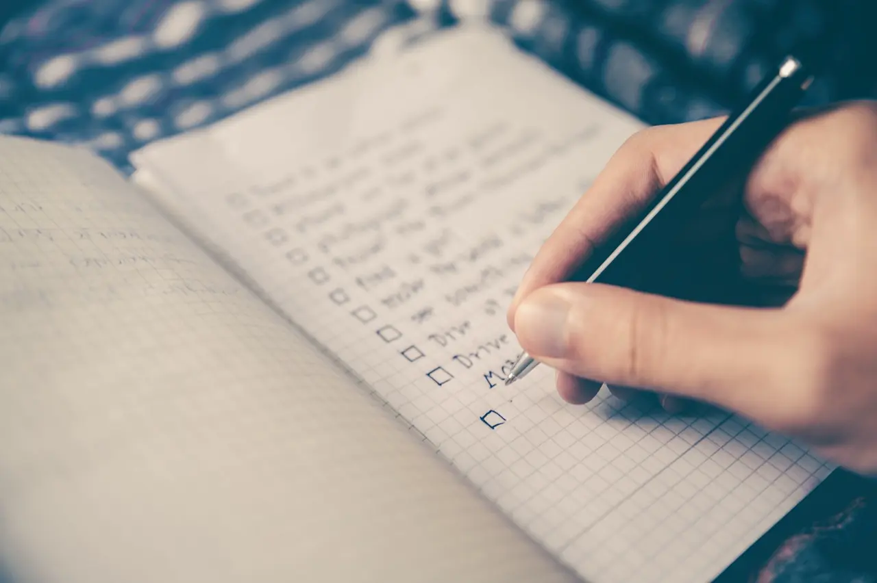 Uma com mão com caneta e um caderno