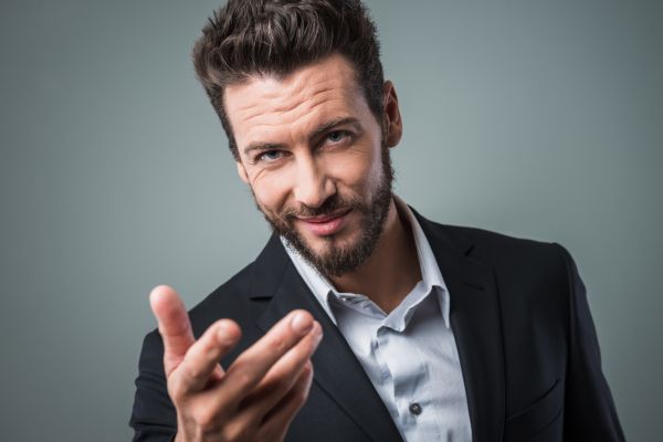 sinais de interesse masculino pela mulher Homem de barba com braço esticado sorrindo