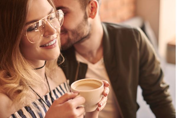 sinais de interesse masculino pela mulher homem perto do ouvido da mulher com uma xícara
