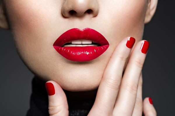 mulher com a mão na boca com batom vermelho