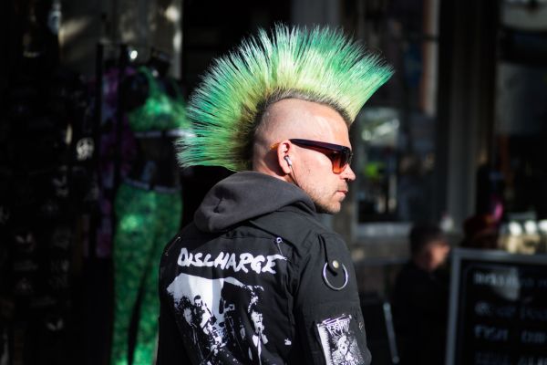 arquetipo do rebelde homem skinhead com cabelo verde e jaqueta preta