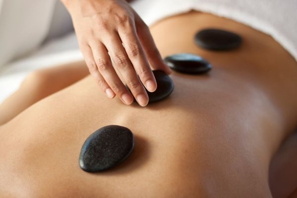 pedras em cima de uma barriga representando terapia holística