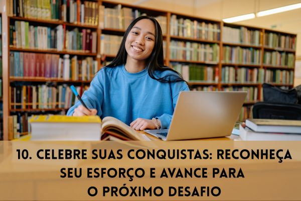 uma aluna com blusa azul com livro aberto e laptop com caneta na mão sorrindo dentro da biblioteca