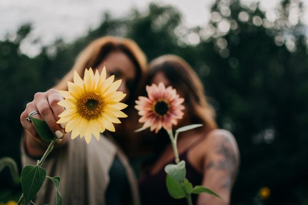 amizade duas mulheres abraçadas com uma flor na mão
